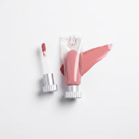 mew lip glaze in Petal, a peach glow, with applicator and swatch